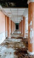 Abandoned hallway with columns in a derelict building photo