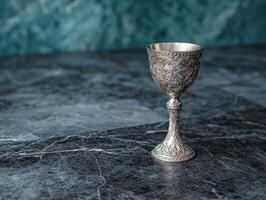 Ornate silver goblet on a marble surface photo