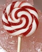 A red and white spiral lollipop on a stick photo