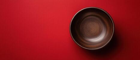 Empty rustic bowl on a textured red surface photo