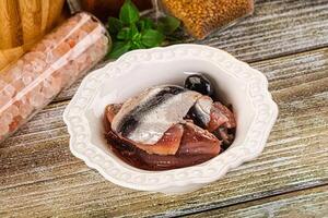 A bowl of fish and spices on a wooden table photo