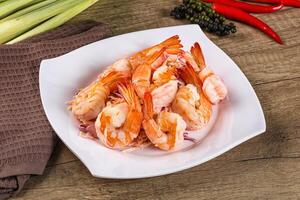 A white plate with shrimp and peppers on it photo