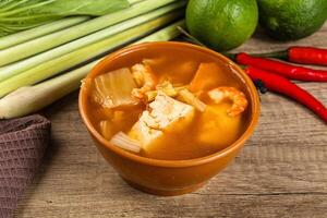 A bowl of soup with a green pepper and a lime photo