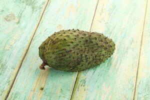A single fruit is sitting on a wooden table photo