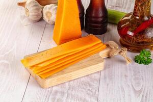 A cutting board with cheese and other ingredients photo