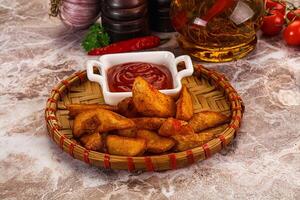 A basket of fries and a bottle of ketchup photo