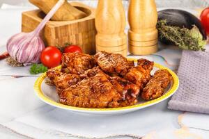Chicken wings on a plate with a knife and a bottle of sauce photo