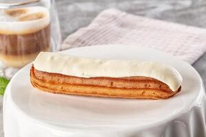 A pastry on a plate with a drink next to it photo