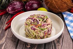 A bowl of food on a table with a coconut and other vegetables photo