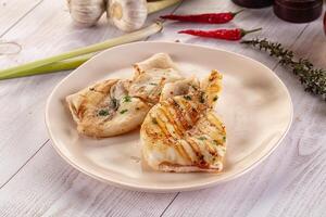 A plate of food on a table with a knife and a garlic clove photo