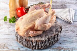 A chicken on a wooden table with a knife photo