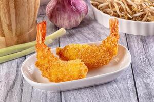 Two fried shrimp on a plate with a bowl of rice photo
