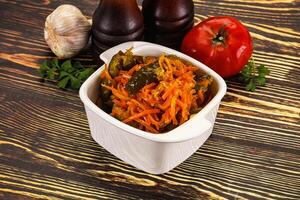 A white bowl with vegetables and a bottle of ketchup photo