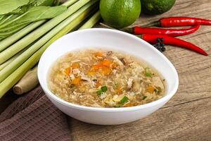 A bowl of soup with vegetables and a pepper photo