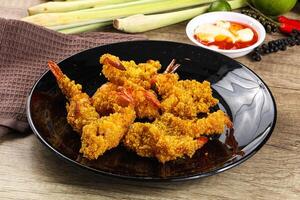 A plate of fried shrimp on a table with some other food photo