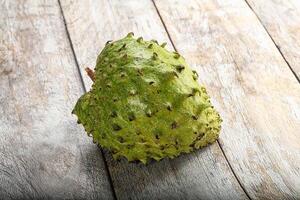 A single fruit sitting on a wooden surface photo