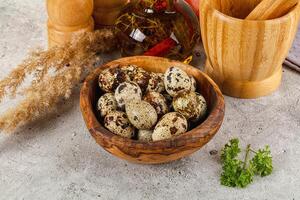 A bowl of quail eggs and herbs on a table photo