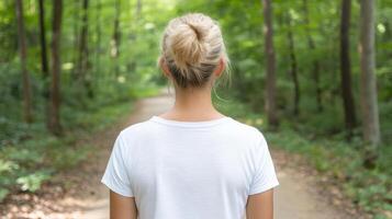 person stands in serene forest, surrounded by lush greenery, contemplating path ahead photo
