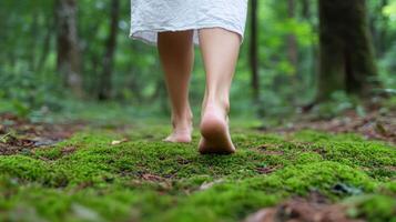 Barefoot walking slowly across mossy ground in serene forest setting photo