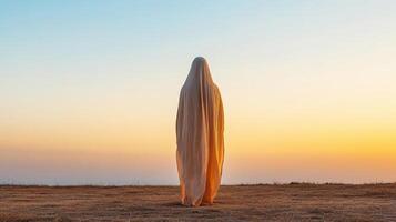 figure draped flowing cloak stands against serene sunset, evoking sense of mystery photo