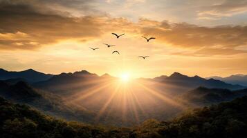 Sunrise over mountains with birds flying over them photo