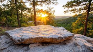 A rock sits on top of a hill at sunset photo