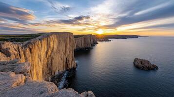 Golden hour over remote coastline with steep cliffs and tranquil sea creates serene atmosphere photo