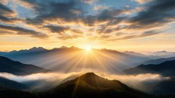 Breathtaking sunrise over misty mountains, with rays of light breaking through clouds photo