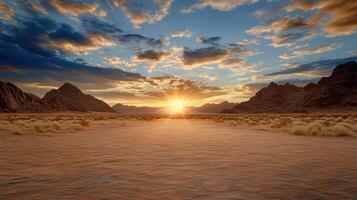The sun rises over a desert landscape with mountains in the background photo