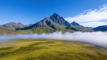 Majestic mountain peaks rise above early morning mist, creating serene landscape photo
