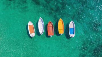 Colorful boats floating in clear turquoise water create serene and picturesque scene photo