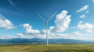 A wind turbine on a green field with blue skies photo