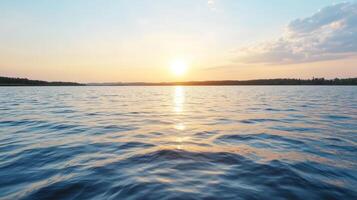Sunset over calm lake water reflecting golden light, creating serene atmosphere photo