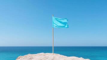 Blue flag on top of cliff with ocean in background photo