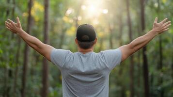 A man with arms outstretched in the forest photo