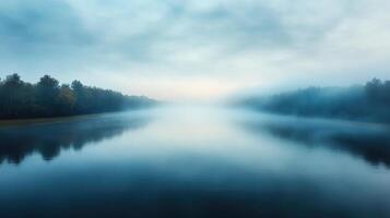 Misty water landscape reflecting trees and sky creates serene atmosphere photo