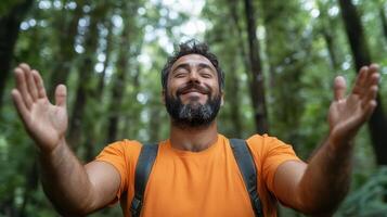 Joyful man with arms open wide in lush green forest, embracing nature beauty photo