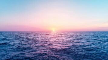 Serene ocean waves gently glowing with light from sun on horizon photo