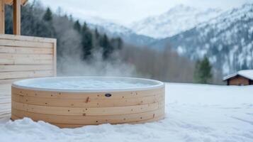 Steamy wooden hot tub in snowy landscape with mountains in background, creating serene retreat photo