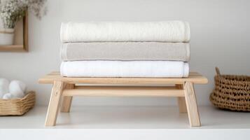 Soft towels stacked on wooden drying rack, creating serene and organized space photo