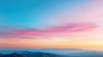 Pastel twilight sky above mountain ridge with soft clouds creating serene atmosphere photo
