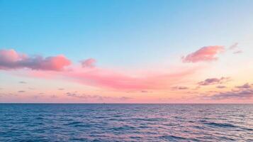 Serene ocean view at sunset with soft pink clouds and calm waves reflecting sky colors photo
