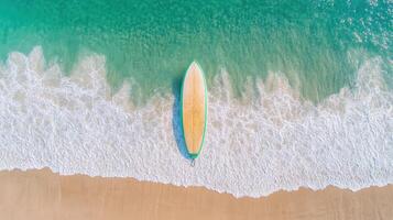 Surfboard resting on sandy beach with gentle waves lapping at shore photo