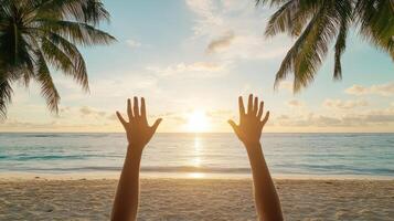 Hands reaching up to the sky on a tropical beach photo