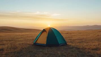 A tent is set up in the middle of a field at sunset photo
