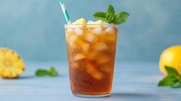 A glass of iced tea with a straw and mint leaves photo