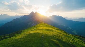 A person walking on a mountain top at sunset photo