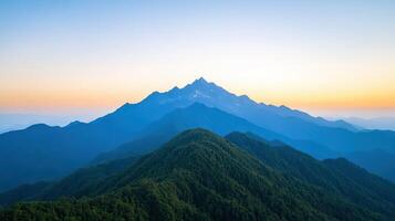 A mountain range with a blue sky and a sunset photo