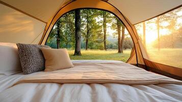 A bed inside a tent with a view of trees photo