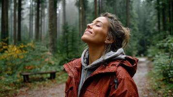 A woman in a red jacket standing in the woods photo